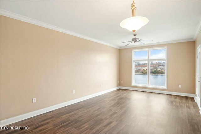 spare room featuring dark hardwood / wood-style flooring, ceiling fan, and crown molding