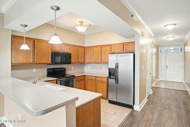 kitchen featuring hanging light fixtures, crown molding, sink, appliances with stainless steel finishes, and kitchen peninsula