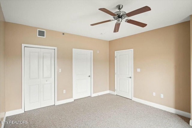 unfurnished bedroom featuring carpet, a closet, and ceiling fan