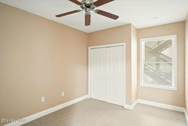 unfurnished bedroom with ceiling fan, light colored carpet, and a closet