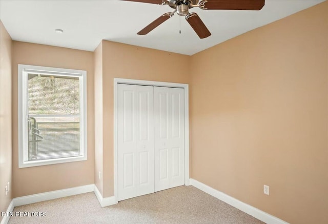 unfurnished bedroom featuring ceiling fan, a closet, and carpet floors