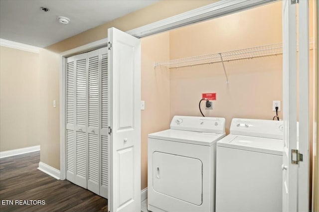 clothes washing area featuring crown molding, dark wood-type flooring, and washer and dryer