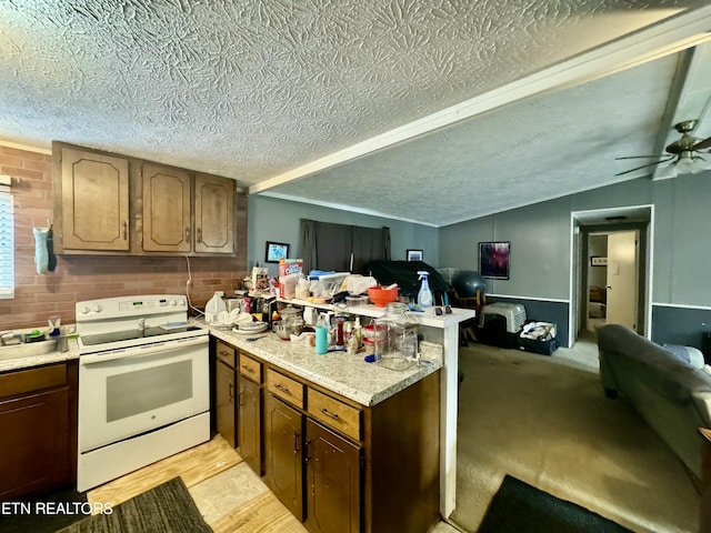 kitchen with light carpet, kitchen peninsula, a textured ceiling, white range with electric cooktop, and lofted ceiling