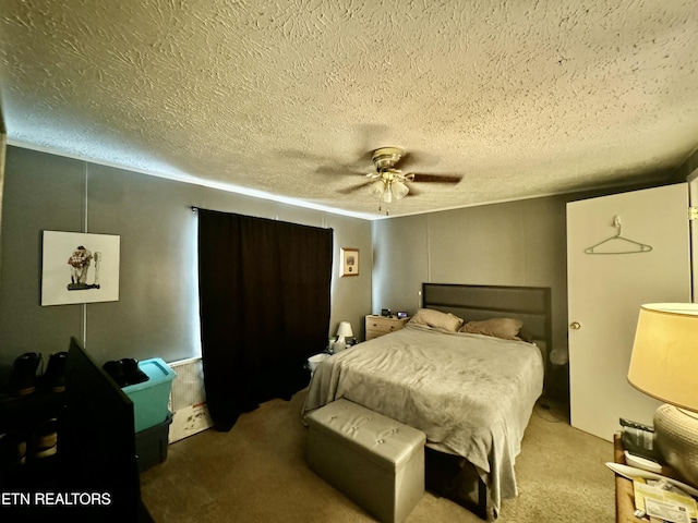 bedroom with ceiling fan, carpet, and a textured ceiling