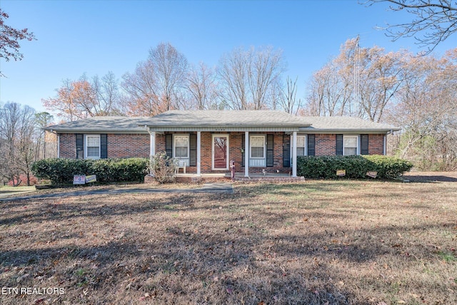 ranch-style home with covered porch and a front lawn