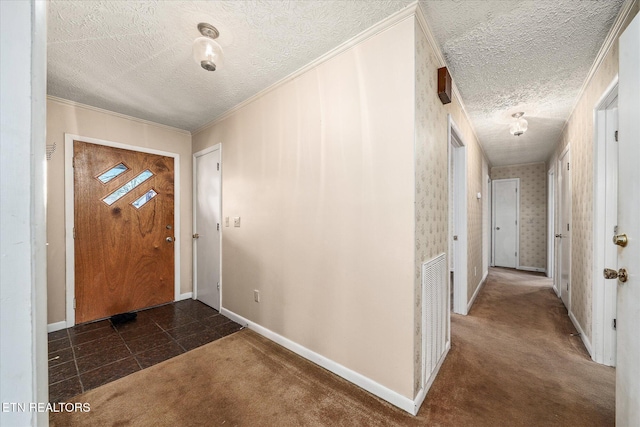 carpeted foyer with crown molding and a textured ceiling