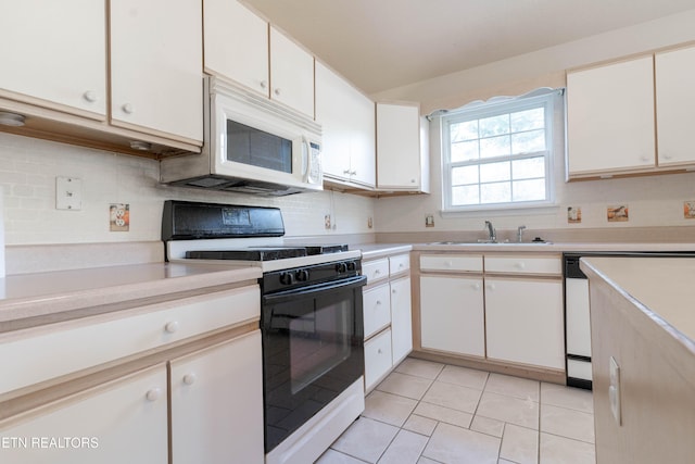 kitchen featuring sink, white cabinets, light tile patterned flooring, and white appliances