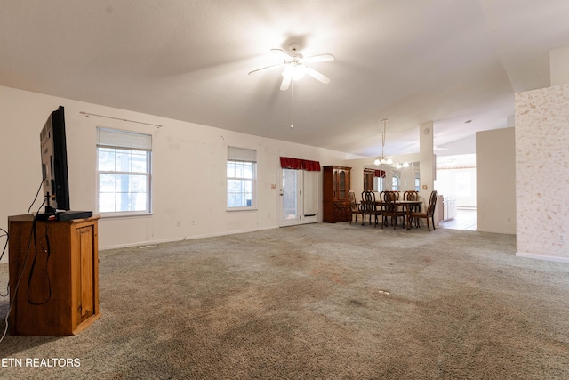 unfurnished living room with carpet, ceiling fan with notable chandelier, and lofted ceiling