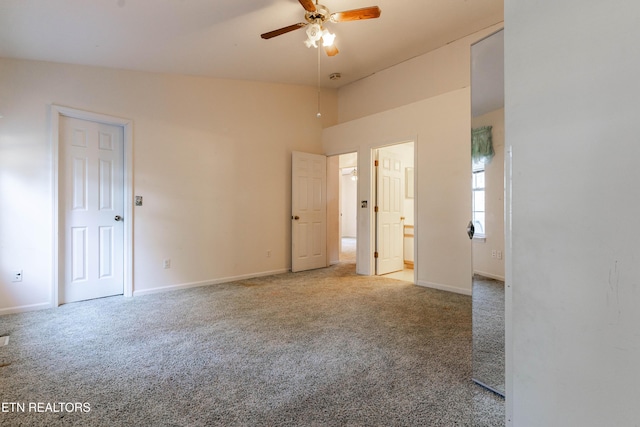 unfurnished bedroom featuring carpet flooring, ensuite bath, ceiling fan, and lofted ceiling