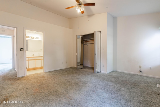 unfurnished bedroom with ensuite bath, ceiling fan, a closet, and carpet