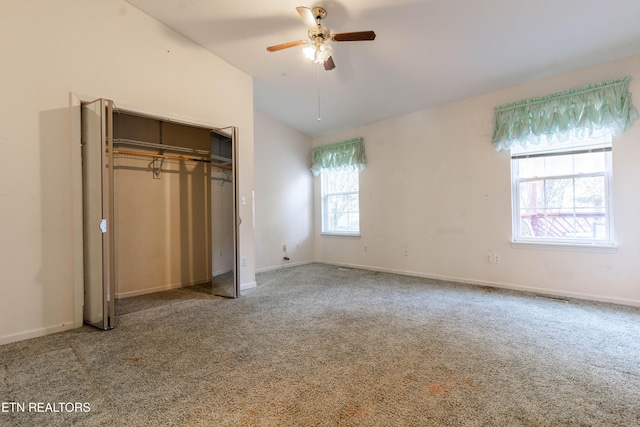 unfurnished bedroom featuring carpet flooring, ceiling fan, lofted ceiling, and multiple windows