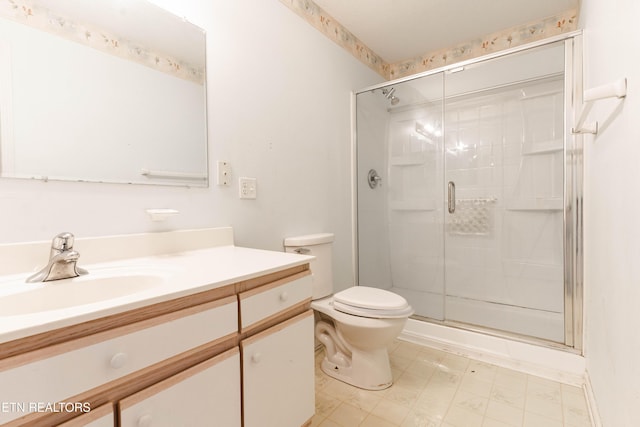 bathroom featuring vanity, toilet, and an enclosed shower