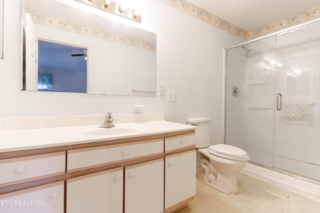 bathroom with vanity, toilet, and a shower with door