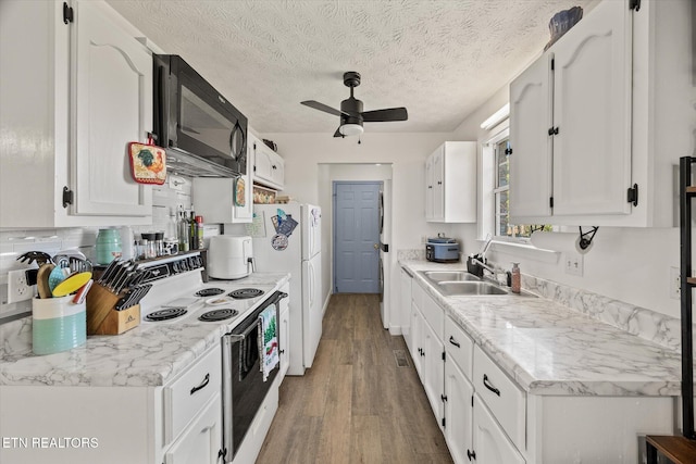 kitchen with a textured ceiling, sink, electric stove, wood-type flooring, and white cabinets