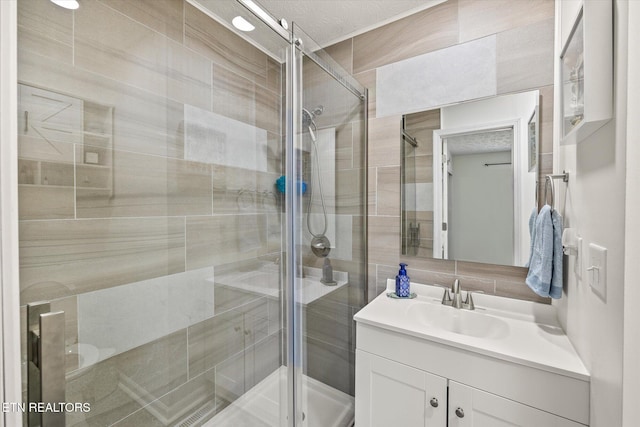 bathroom with vanity, a textured ceiling, and walk in shower