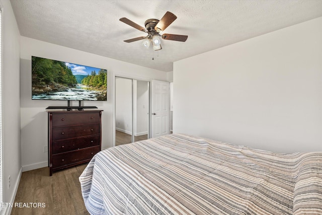 bedroom featuring ceiling fan, light wood-type flooring, a textured ceiling, and a closet