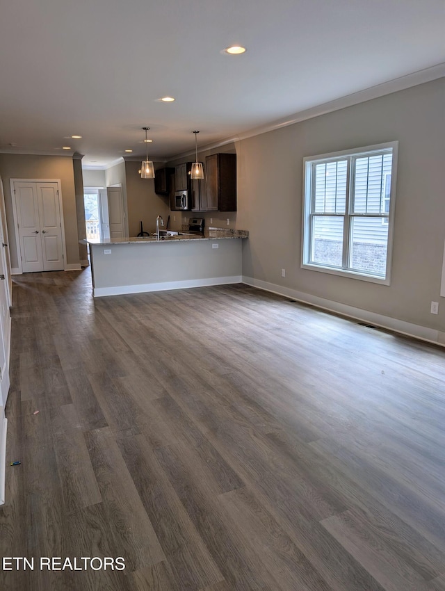 unfurnished living room with dark wood finished floors, crown molding, and a wealth of natural light