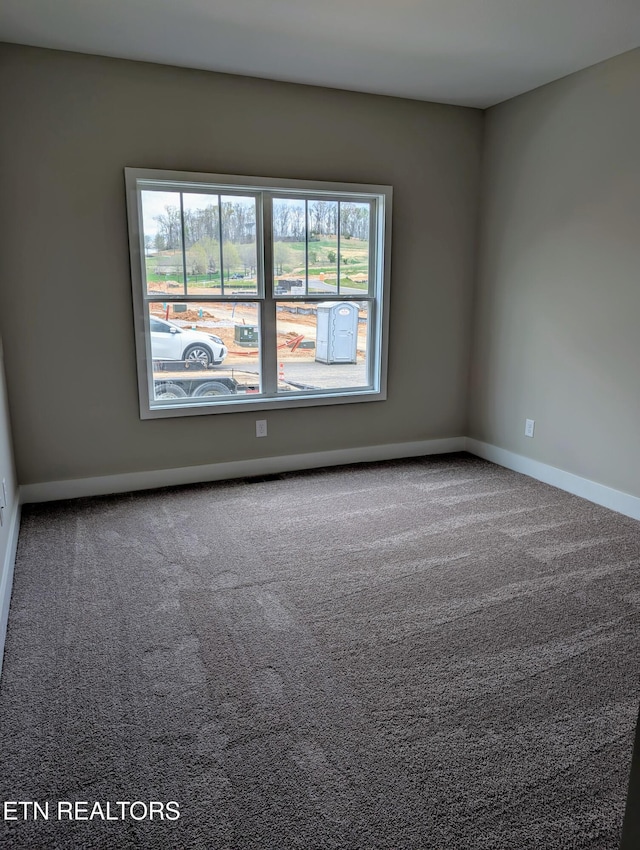 unfurnished room with carpet and baseboards
