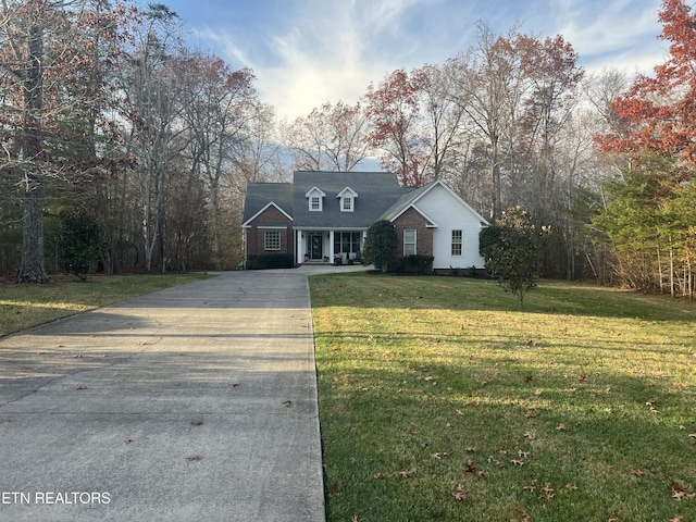 cape cod home with a front lawn