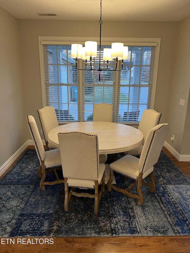 dining room featuring hardwood / wood-style floors and an inviting chandelier