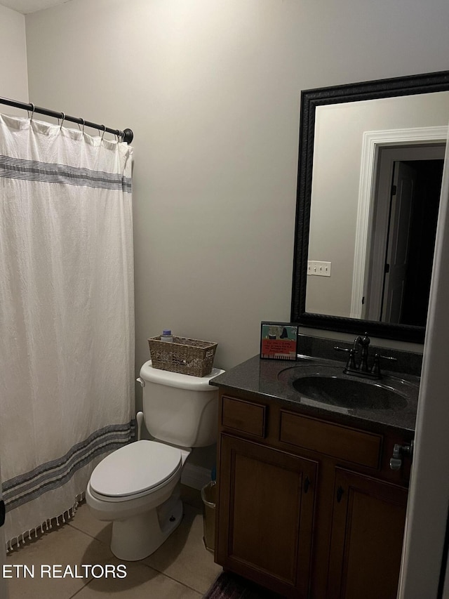 bathroom with tile patterned flooring, vanity, and toilet