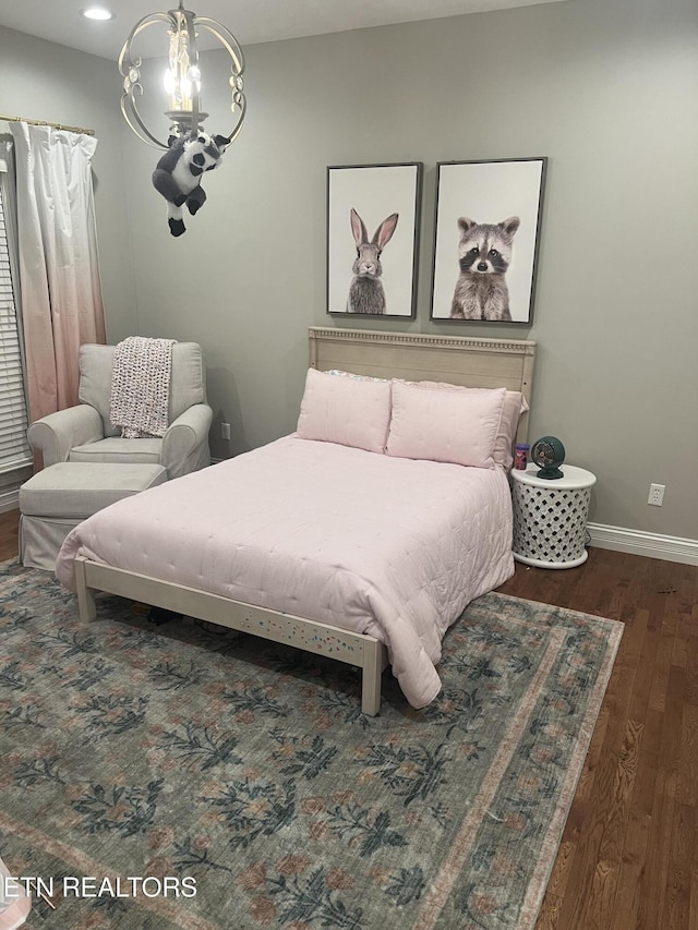 bedroom featuring dark hardwood / wood-style flooring and a notable chandelier