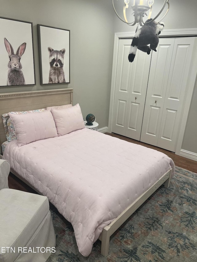 bedroom featuring a closet, a chandelier, and dark hardwood / wood-style floors