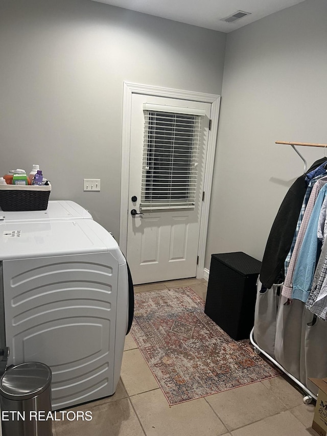 washroom with washer and clothes dryer and light tile patterned floors