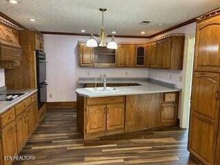 kitchen with dark hardwood / wood-style flooring, black double oven, hanging light fixtures, and crown molding