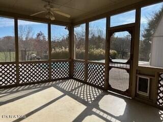 unfurnished sunroom featuring ceiling fan