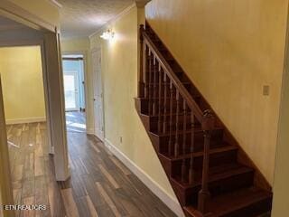 stairway featuring crown molding and hardwood / wood-style flooring