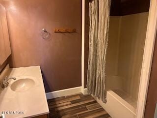 bathroom featuring hardwood / wood-style floors, vanity, and shower / bathtub combination with curtain