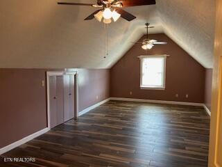 additional living space with ceiling fan, lofted ceiling, and dark wood-type flooring