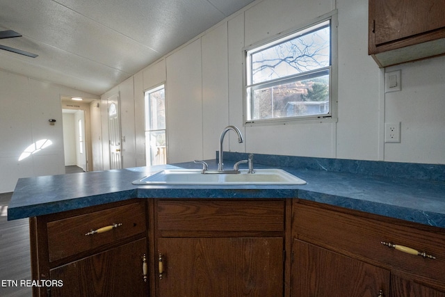 kitchen featuring kitchen peninsula, sink, and vaulted ceiling