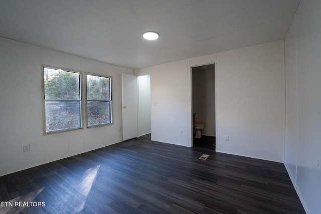 empty room with dark hardwood / wood-style flooring