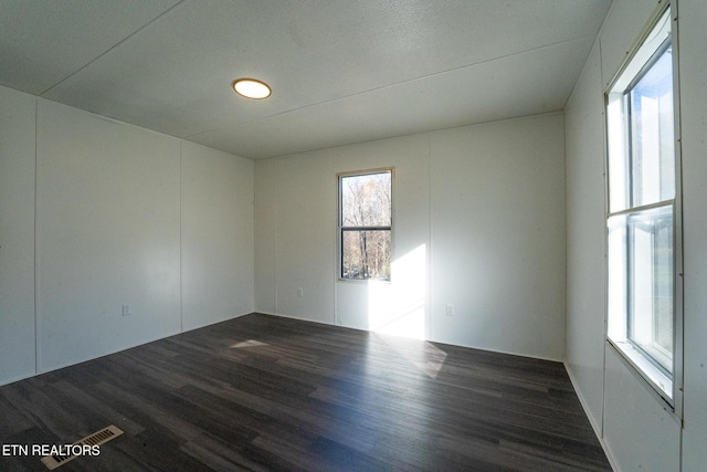 unfurnished room with dark hardwood / wood-style flooring