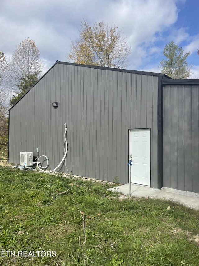 view of outbuilding featuring ac unit and a yard