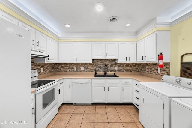 kitchen featuring custom exhaust hood, white appliances, white cabinets, sink, and independent washer and dryer