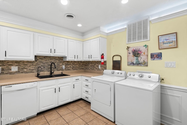 clothes washing area with washing machine and clothes dryer, sink, and light tile patterned floors