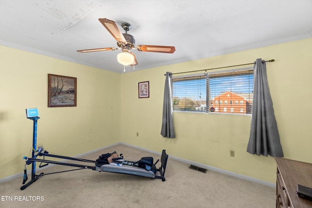 exercise room with ceiling fan, light colored carpet, and ornamental molding