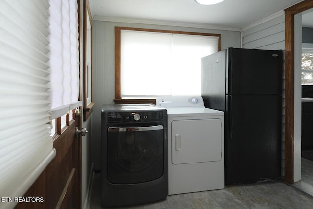 washroom with a healthy amount of sunlight, washing machine and dryer, and ornamental molding