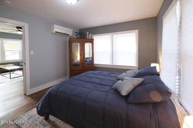 bedroom with wood-type flooring and a wall mounted AC