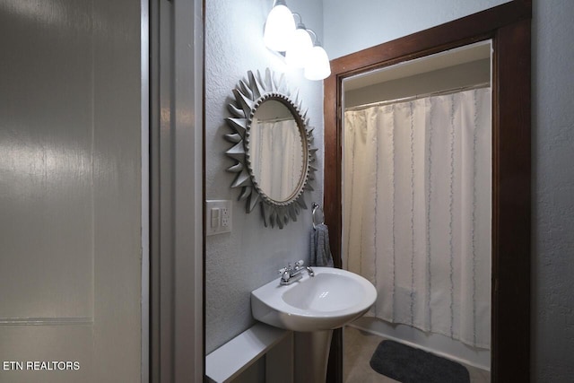 bathroom with curtained shower and sink