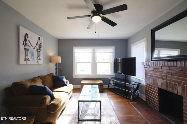 living room featuring ceiling fan, dark wood-type flooring, and a brick fireplace