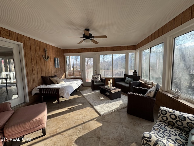 bedroom with ceiling fan, light tile patterned floors, and wooden walls