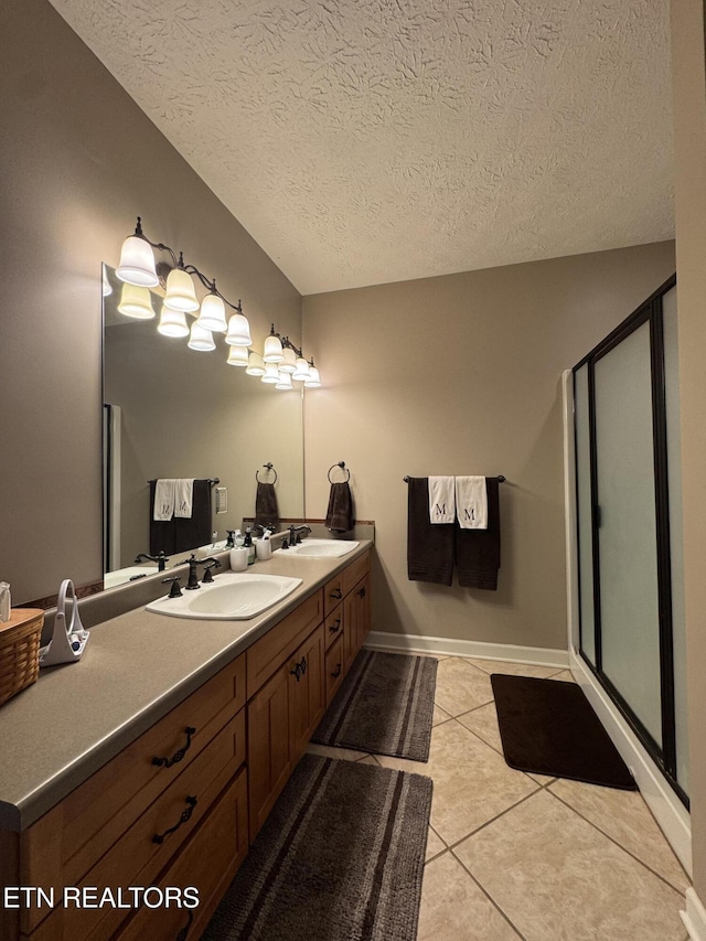 bathroom featuring a shower with door, a textured ceiling, vanity, and tile patterned flooring