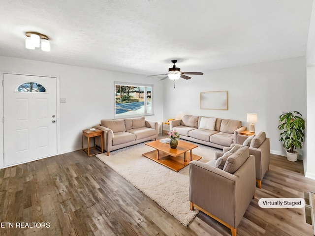 living room with ceiling fan and dark wood-type flooring