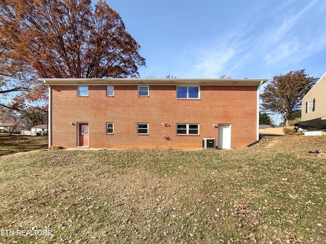 rear view of house with a lawn and cooling unit