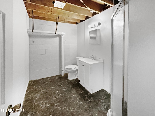 bathroom featuring vanity, concrete flooring, and toilet