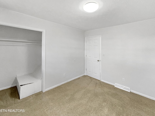 unfurnished bedroom with carpet and a closet